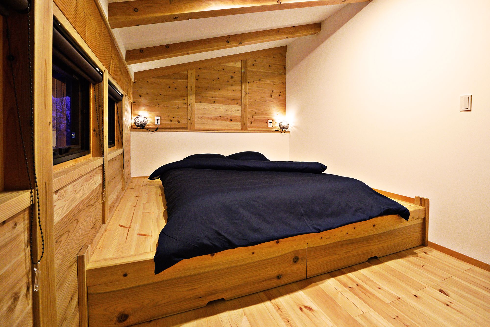 Main bedroom set up with a double bed on a raised timber base