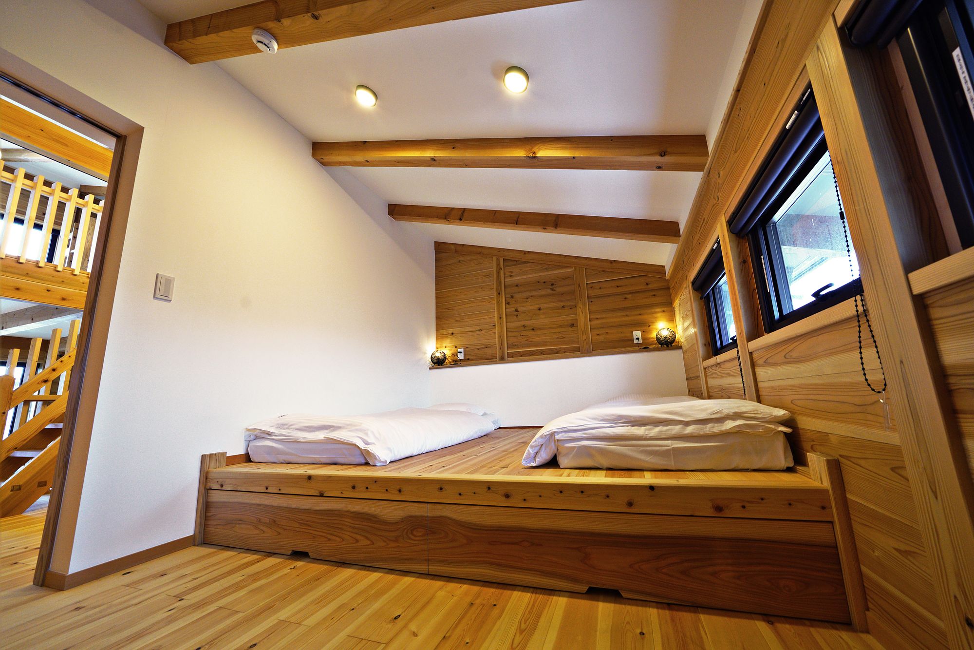 Main bedroom set up with two single beds on a raised timber platform