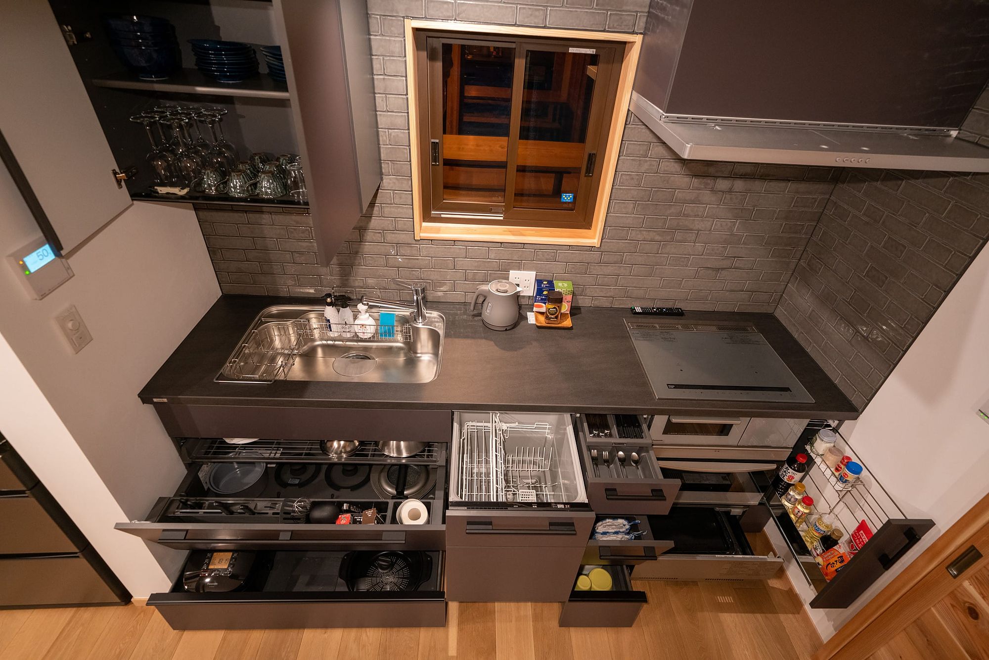 Kitchen with deep drawers of cookware, a dishwasher and an induction hob